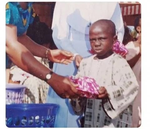 A child frowning while holding a wrapped gift